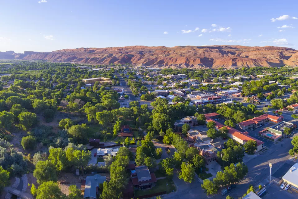 Aerial view of Moab, Utah with red mountains in background.